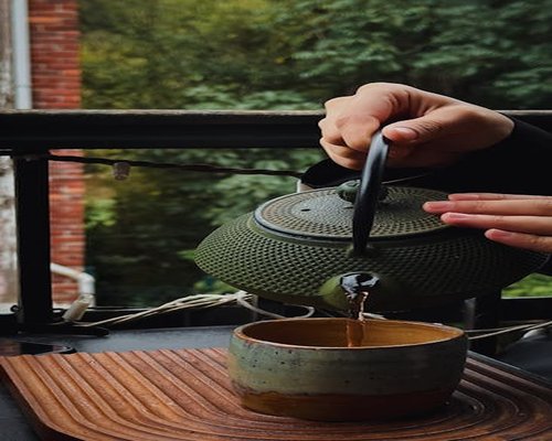 Indian person relaxing with a cup of tea on a balcony